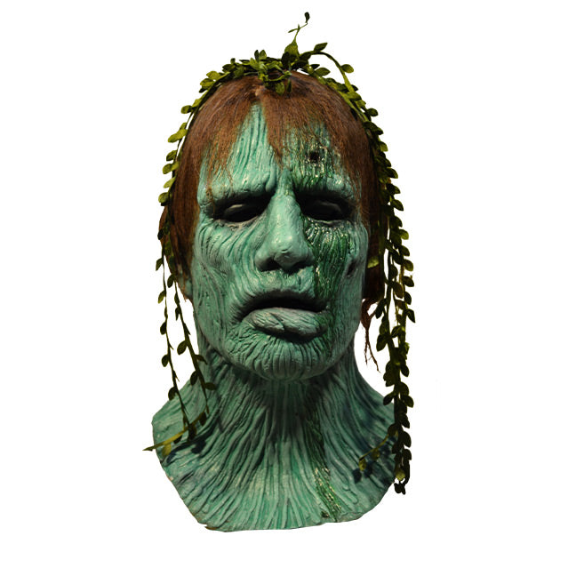 Front view, Creepshow Harry Mask. Head and neck of man. Red brown straight hair, with seaweed in it, green wrinkled mossy skin, eyes appear closed. hole in forehead oozing dried green fluid.