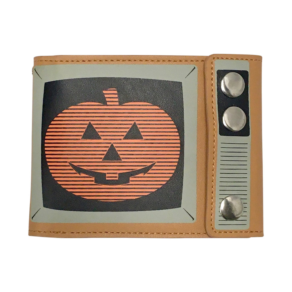 Magic Pumpkin TV wallet, front view, closed.  Made to look like a vintage television. Tan background black and white details, screen shows orange jack o' lantern with horizontal black stripes on black background.  Three silver snaps in place of TV knobs.