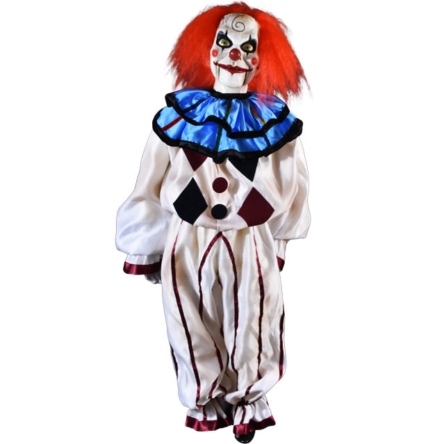 Mary Shaw Clown Puppet prop. Distressed finish white skin, ventriloquist dummy clown face, spiral curl drawn on forehead, rosy red spots on cheeks, red nose, bright red hair, black-rimmed, bloodshot green eyes. Bright red grinning lips, hinged lower jaw. Wearing clown suit, blue and black ruffled collar, white shirt with black and burgandy diamonds and buttons, ruffled sleeves.  White pants with thin burgandy stripes