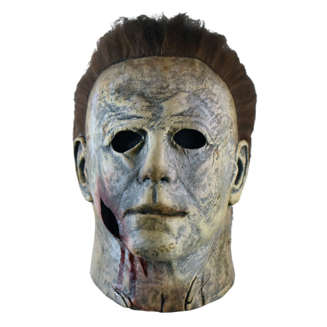 Front  view, mask, head and neck.  Aged and distressed gray skin, dark brown hair, large bloody wound on right jaw.