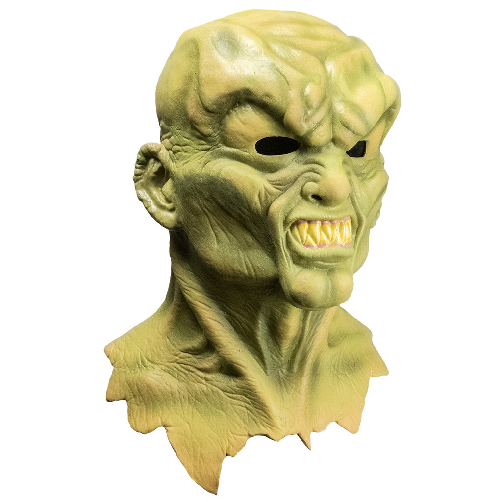 Mask, right side view. Head neck and upper chest. Greenish flesh, lumpy, misshapen bald head, Heavy brow over angry face, snarling mouth full of large sharp teeth.