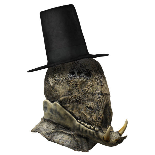 right side view. Scarecrow mask head and neck. Burlap textured face. Non-descript upper facial features, prominent lower jaw with 2 large tusks. Wearing tall black hat.