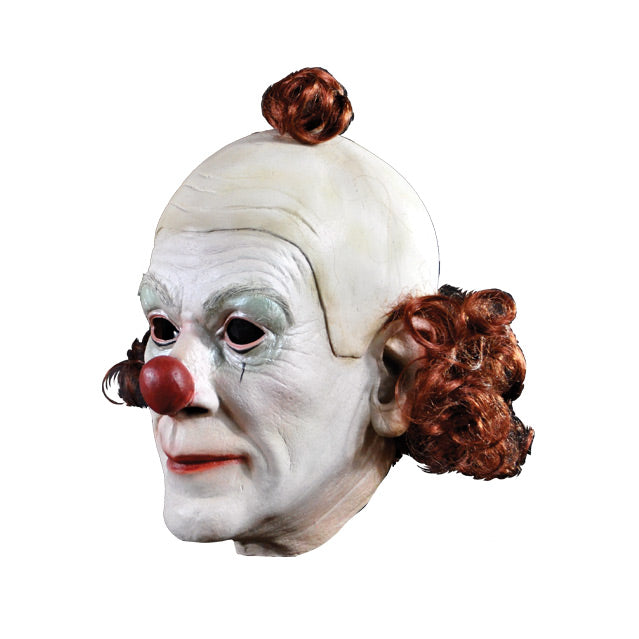 Left side View. Clown Mask. White face, red nose, one small black line below each eye. wig partially bald, red hair pompom on top, red curly hair around back ear to ear.