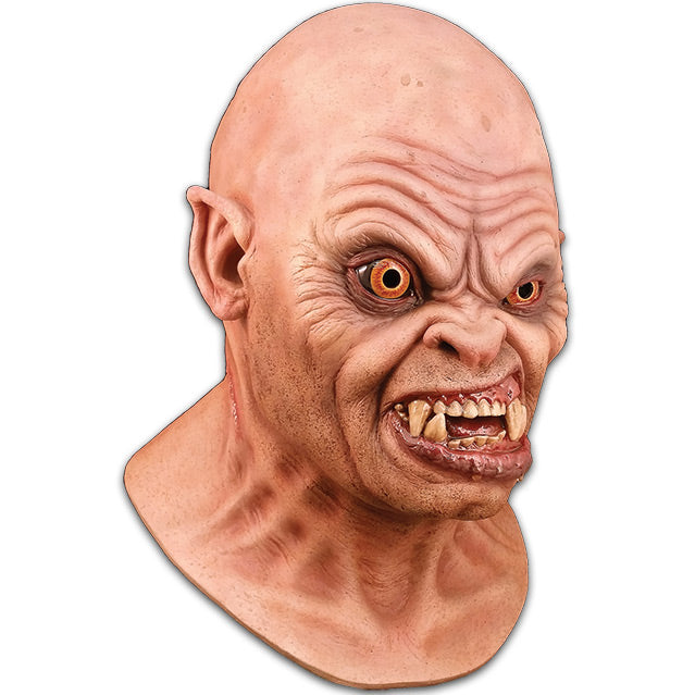 Right side view. Mask, head and neck. Bald head, slightly pointed ears. Creased skin on forehead, around eyes and mouth. Orange eyes, right eye bulging. Snarling mouth with crooked teeth and large fangs.
