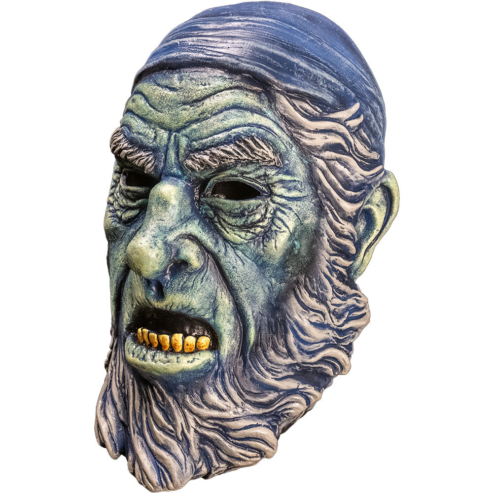 Mask left side view. Old man face, blue wrinkled skin, Blue bandana on head. Gray hair, eyebrows, sideburns and beard. Mouth open showing yellowed bottom teeth.