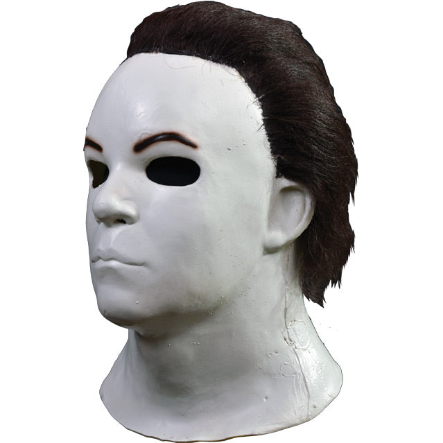 Left side view. Mask, head and neck. Dark brown hair, white skin.