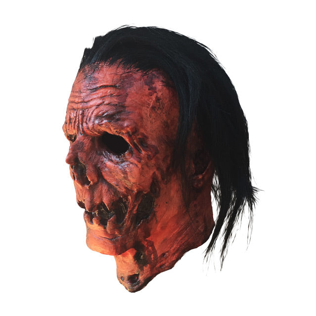Left side view. Jacob Atkins mask. Gory, wrinkled orange Jack o' lantern-like face with stringy black hair.