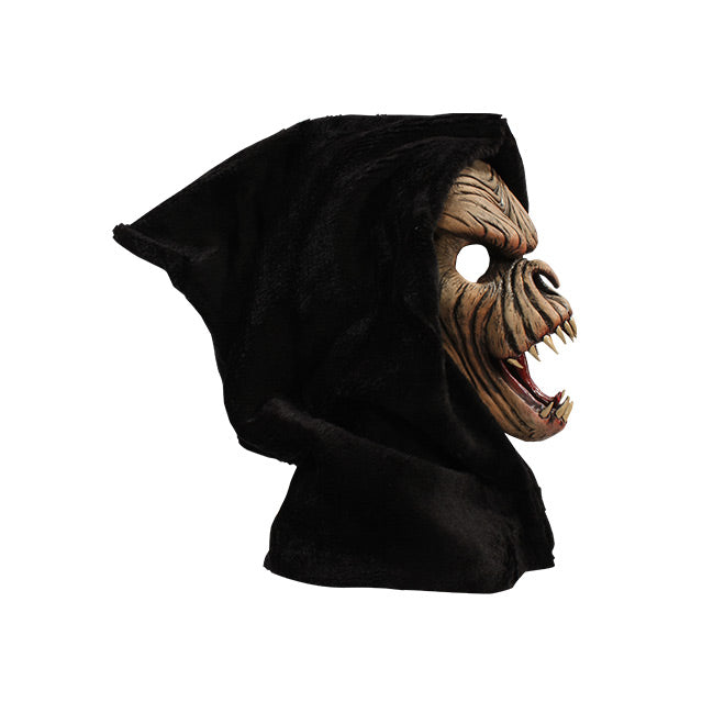 Right side view. Brown faced creature in black hood, wrinkled skin, wide open mouth showing tongue and several large fangs.