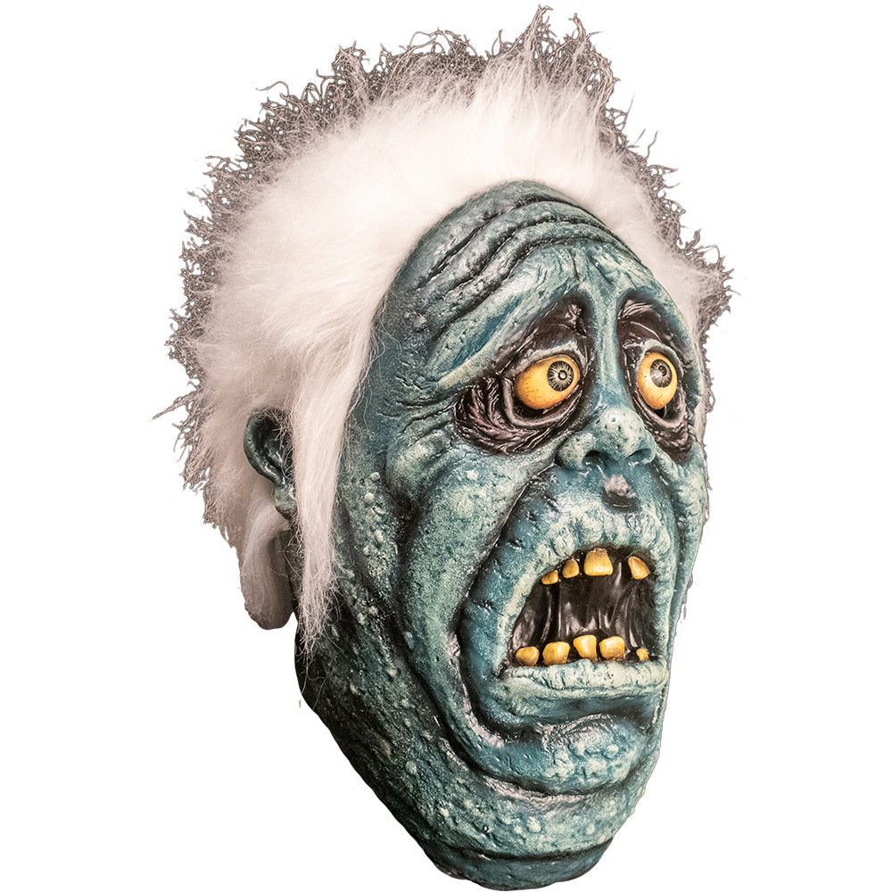Mask right side view. Scared blue face with wrinkled sagging skin, Black circles around yellow eyes with blue irises. Open mouth with crooked yellow teeth. Bright white fluffy hair.