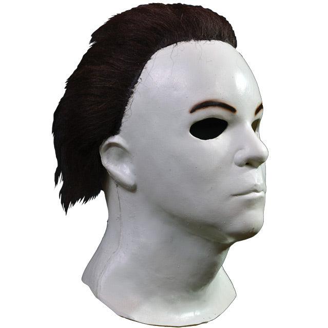 Right side view. Mask, head and neck. Dark brown hair, white skin.