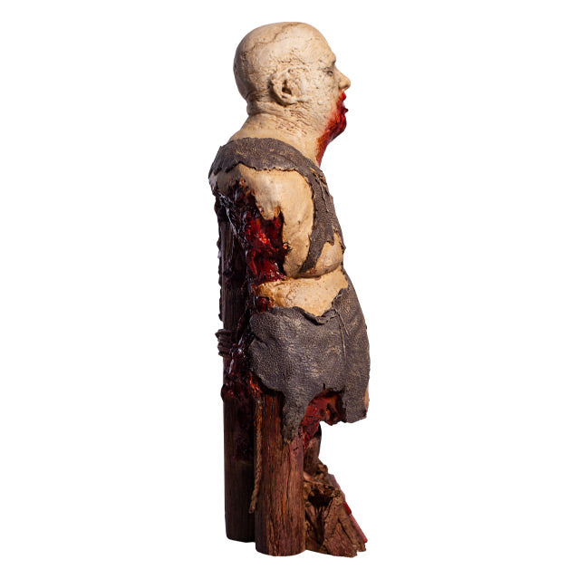 Bust right side view. Zombie, head and torso torn shirt, pot belly. Bald head, eyes closed, gory mouth blood from mouth running down chest, back is gory and bloody. Base is wooden pier posts and rope. Plaque at bottom red text reads Zombie