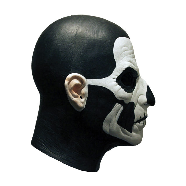 Mask, right side view. Head and neck. Bald, black painted head and neck, white painted face, with black accents to create skull like appearance.