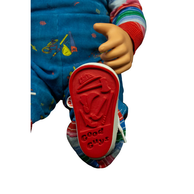 Detail of bottom of Good Guys doll shoe, All red, imprinted with illustrations of fireman hat, axe, cowboy hat, hammer, pistol, baseball bat.  Imprinted text Good Guys.