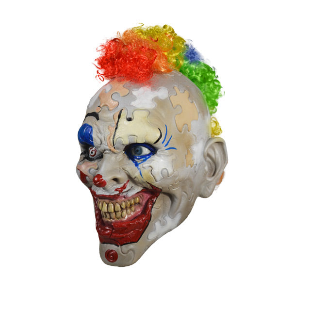 left side view. Creepy clown face. Skin made up of puzzle pieces, gray, white, beige, and peach. Bright red clown mouth smiling with yellowed teeth. Spiral right eye. Rainbow curly mohawk hair.