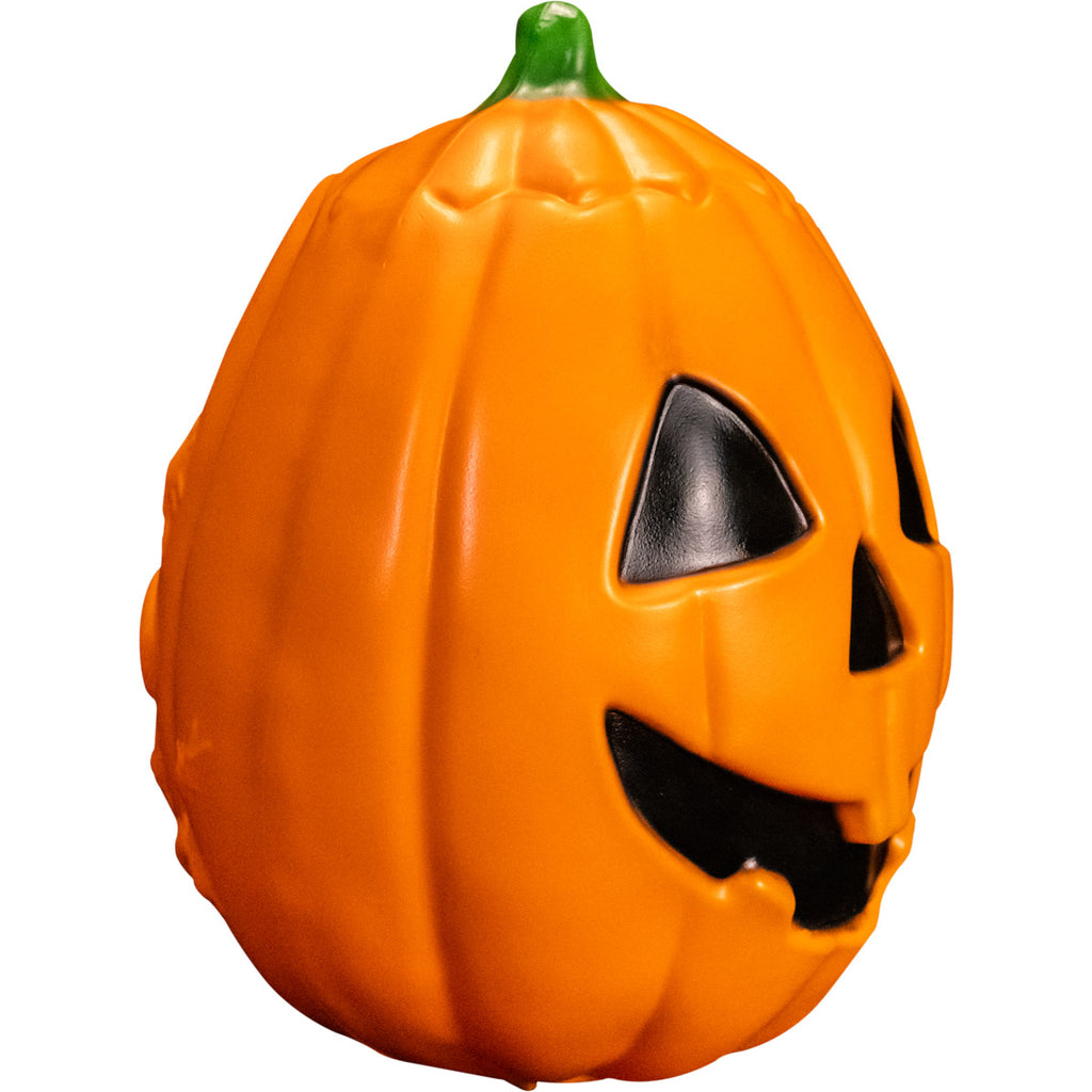 Pumpkin prop, right side view. Orange jack o' lantern, green stem, black triangle eyes and nose, grinning black mouth.