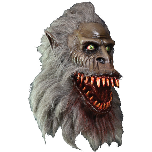 Right side view. Crate Beast mask. Light brown beast face, wrinkled skin, Yellow eyes with vertical long pupils, pointed ears, snout nose, large grinning bloody mouth with many sharp teeth, long gray fur covering head, lower face and neck. Blood stains on fur around mouth and chin.