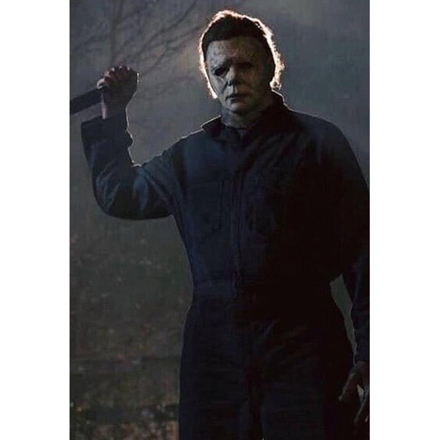 Backlit, Michael Myers wearing dark coveralls, holding knife in right hand.