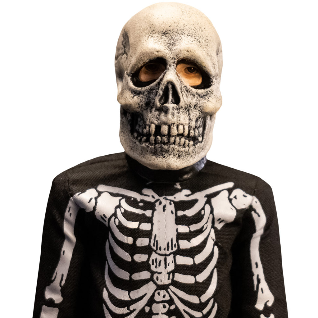 Close up of head and shoulders of skeleton costume figure.  White and black skull mask, wearing black and white skeleton coveralls.