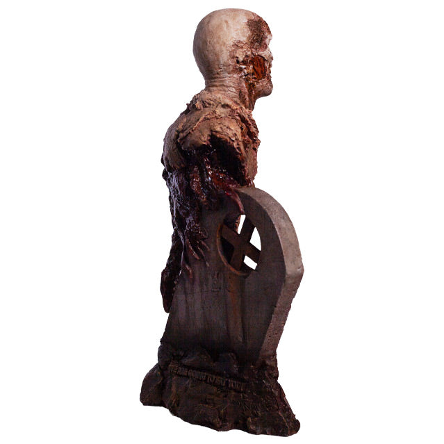 Bust, back right side view. Rotted zombie head neck and upper torso, wearing dirty rotted torn clothing. Gore around shoulders, bottom of torso and back. Base is gravestone set in soil, with zombie arm coming from the ground.