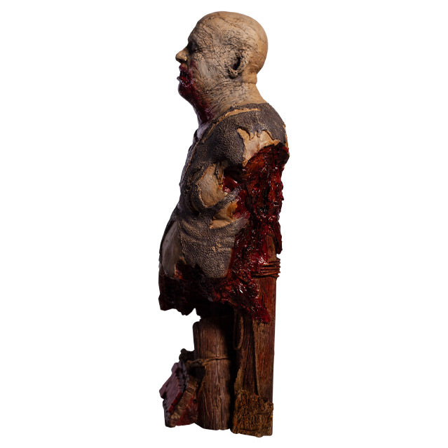 Bust left side view. Zombie, head and torso torn shirt, pot belly. Bald head, eyes closed, gory mouth blood from mouth running down chest, back is gory and bloody. Base is wooden pier posts and rope. 