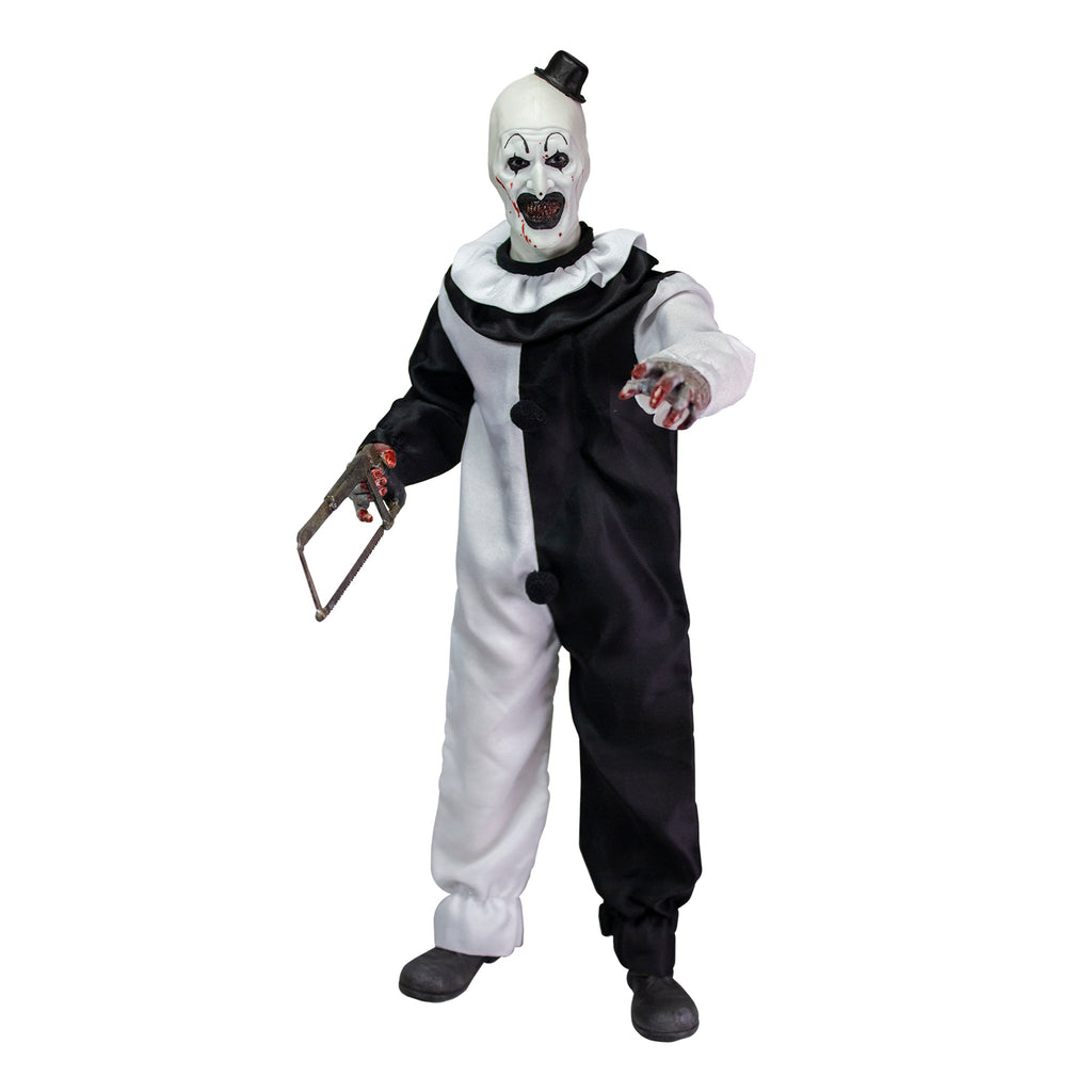 Terrifier, 1/6 scale figure, front view. Evil grinning clown face with tiny black top hat, black and white, jumpsuit, ruffle at neck, fingerless white gloves, dark gray shoes. Blood spatter on face and hands. Holding saw in right hand