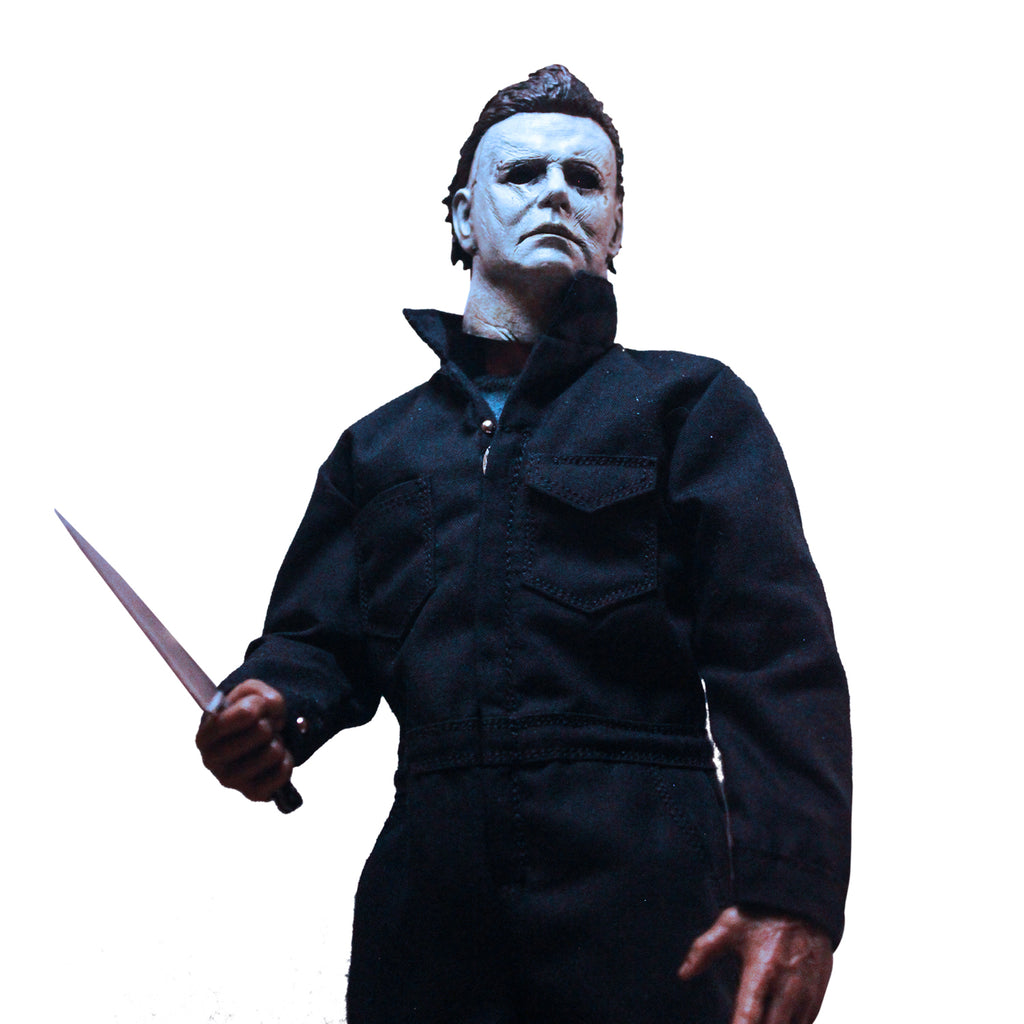 Close up view of Halloween 2018 Michael Myers 12" figure. White mask brown hair, wearing dark coveralls, holding butcher knife in right hand.