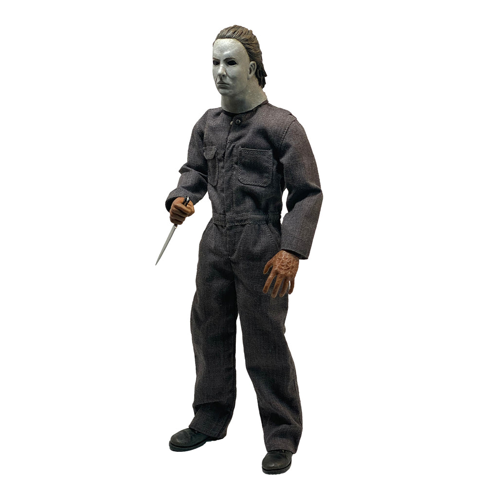Left side view. Halloween 5 Michael Myers 12" figure. White mask brown hair, wearing coveralls, black boots, holding butcher knife in right hand.
