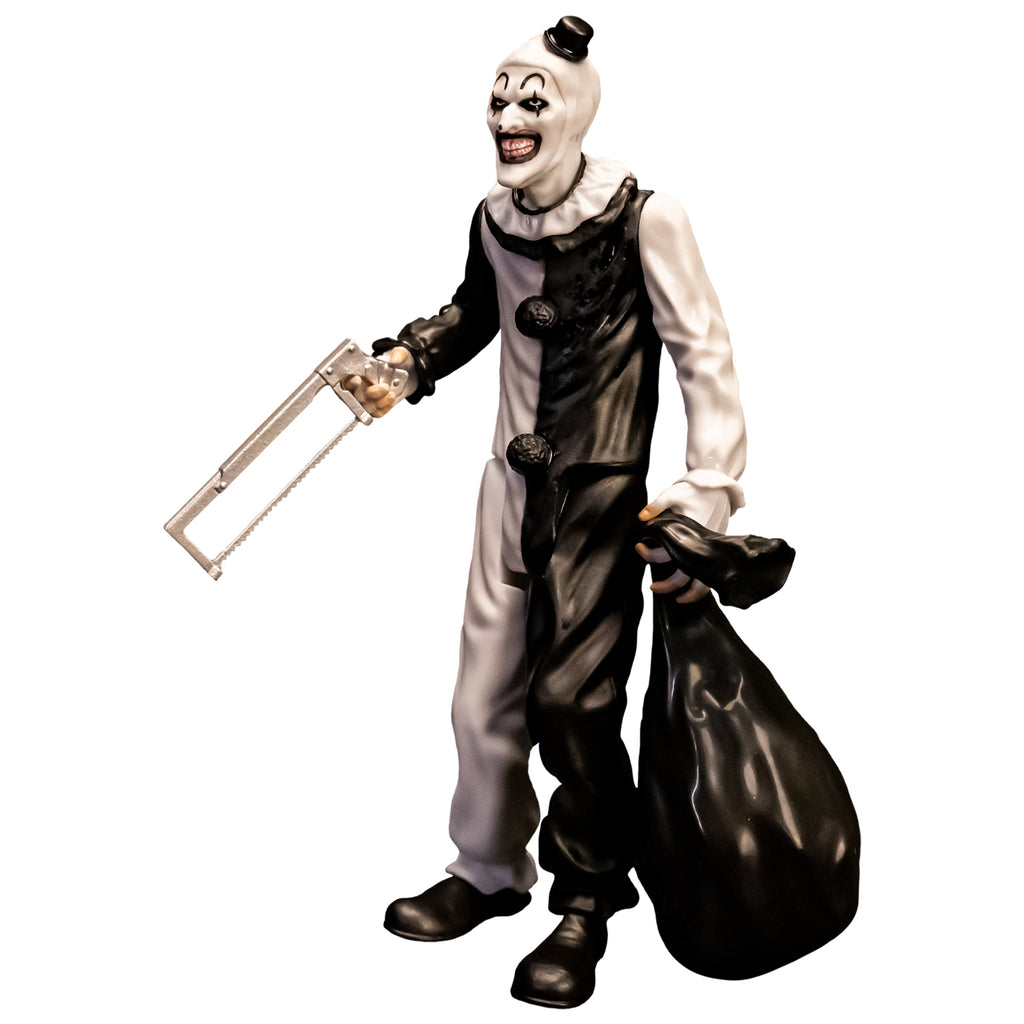 Terrifier, 5 inch figure, left side view. Evil grinning clown face with tiny black top hat, black and white, jumpsuit, ruffle at neck, fingerless white gloves, black shoes. holding saw in right hand, black trash bag in left hand.