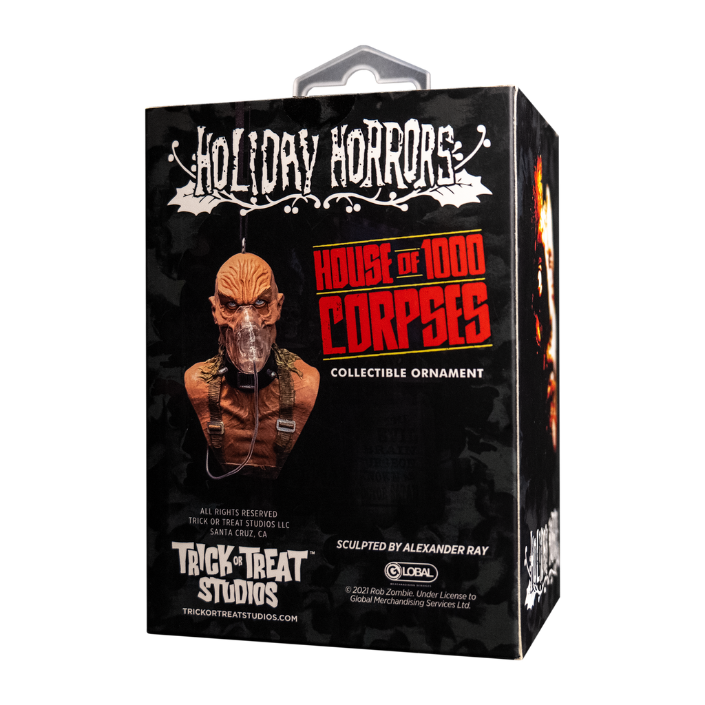 Product packaging, back. Black box, showing ornament. White text reads Holiday Horrors.  Red text reads, House of 1000 Corpses, white text reads collectible ornament. Manufacturing and licensing information.