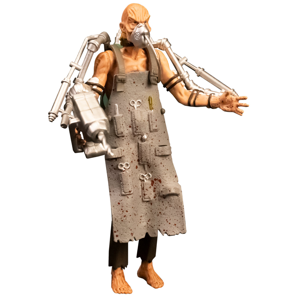 Action figure, right front view. Bald man with wrinkled skin, black collar, wearing oxygen mask, gray apron with pockets holding medical instruments, shirtless, brown tattered pants, bare feet. Silver drill tools attached to both arms with black straps.