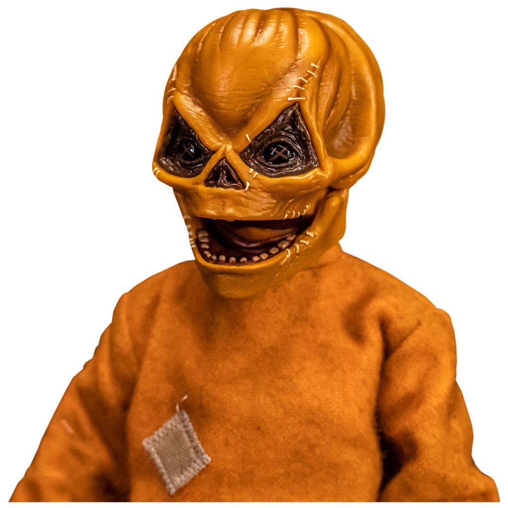 Left view. Close up of upper body and head of Trick 'r Treat Sam 1/6 scale figure with Sam Unmasked head. Head is Skull-like jack o' lantern face, stitches above eyes and sides of mouth, mouth open in grin. Wearing orange footy pajamas