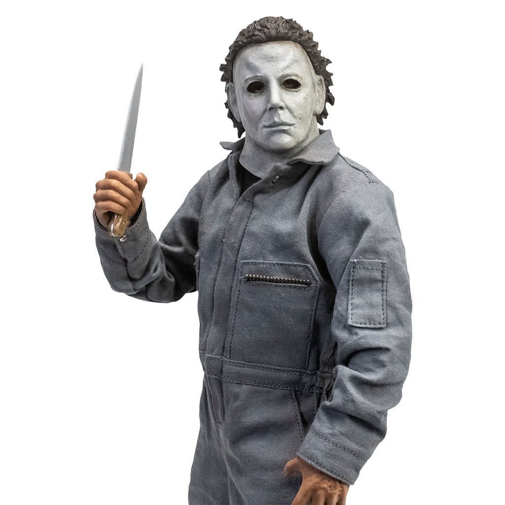 Left side view. Halloween 6 Michael Myers 12" figure. White mask brown hair, wearing coveralls, holding butcher knife in right hand.