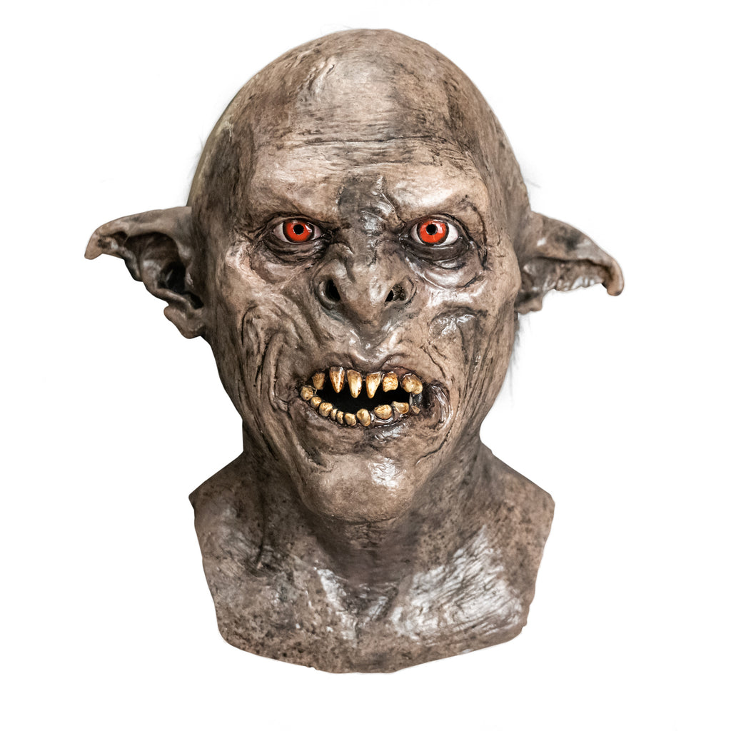 Mask, head, neck and upper chest, front view. Orc, wrinkled gray-brown dirty skin, tattered pointed ears, snarling mouth with dirty sharp teeth. Red-orange eyes