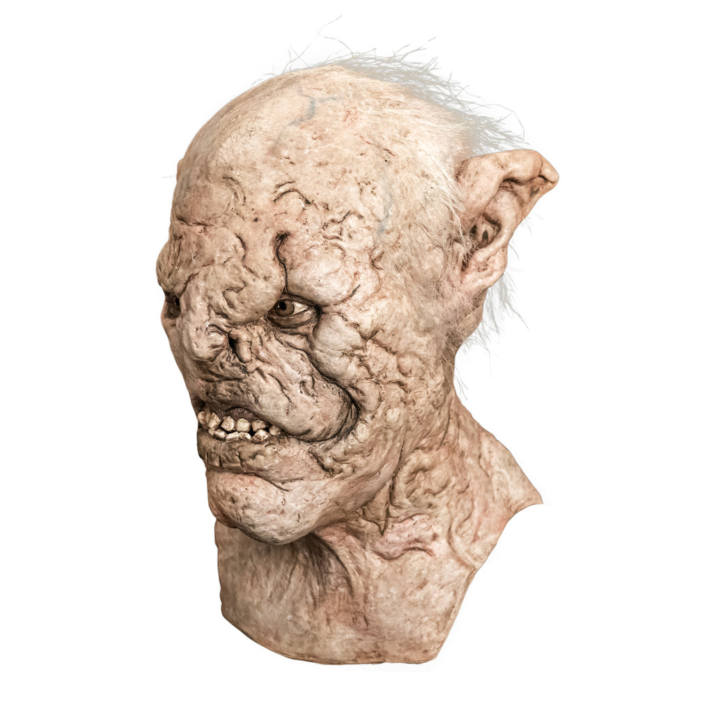 Mask, head, neck and upper chest, left side view. Orc, wrinkled pale skin, tattered high set pointed ears, scar above left eye down nose and side of snarling mouth. Light brown eyes. Sparse gray hair on top and sides of head.