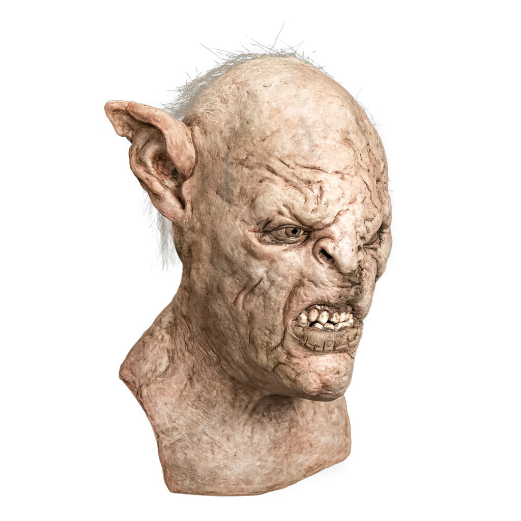 Mask, head, neck and upper chest, right side view. Orc, wrinkled pale skin, tattered high set pointed ears, scar above left eye down nose and side of snarling mouth. Light brown eyes. Sparse gray hair on top and sides of head.