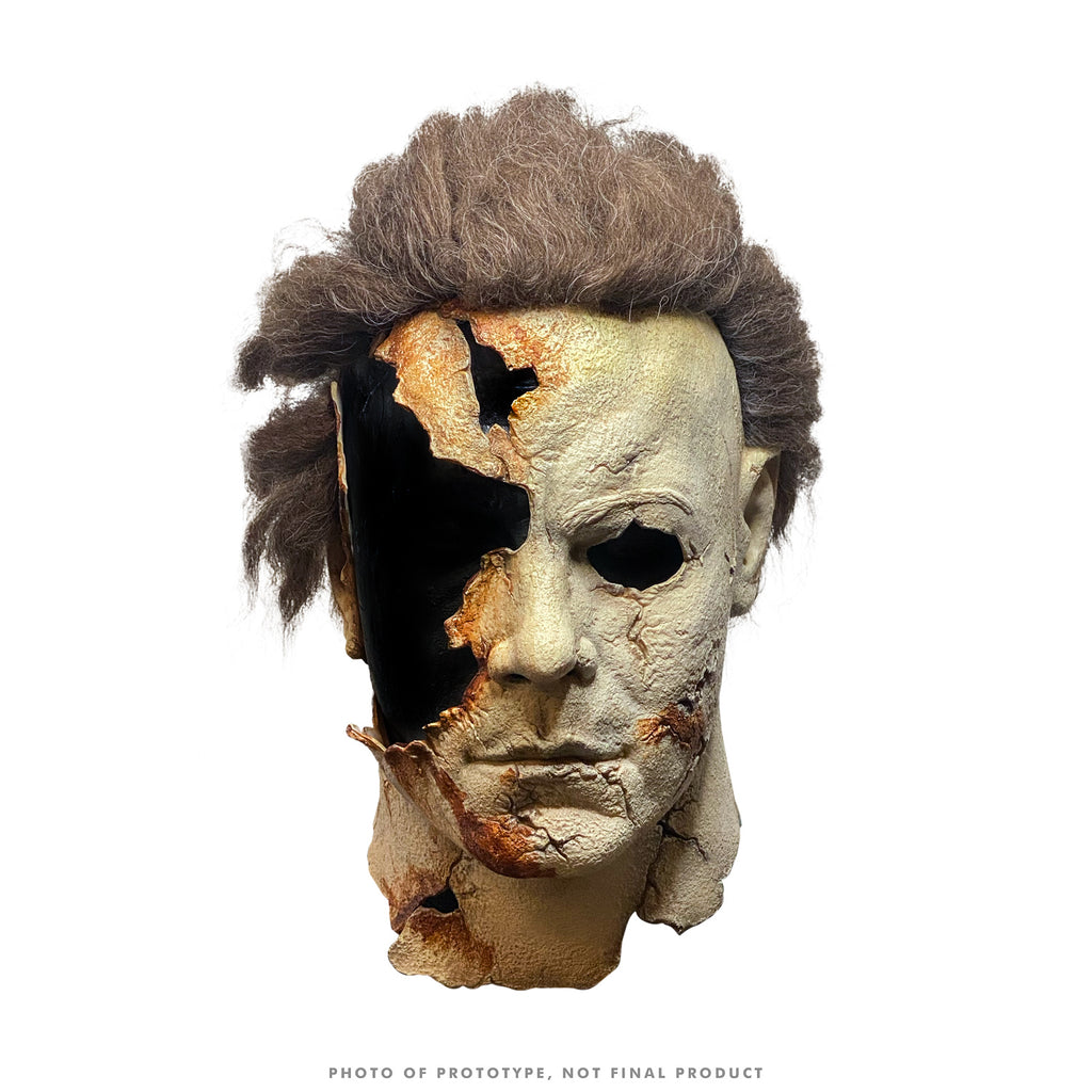 Mask, head and neck. Brown hair, distressed and cracked skin, missing a portion of the upper right side..