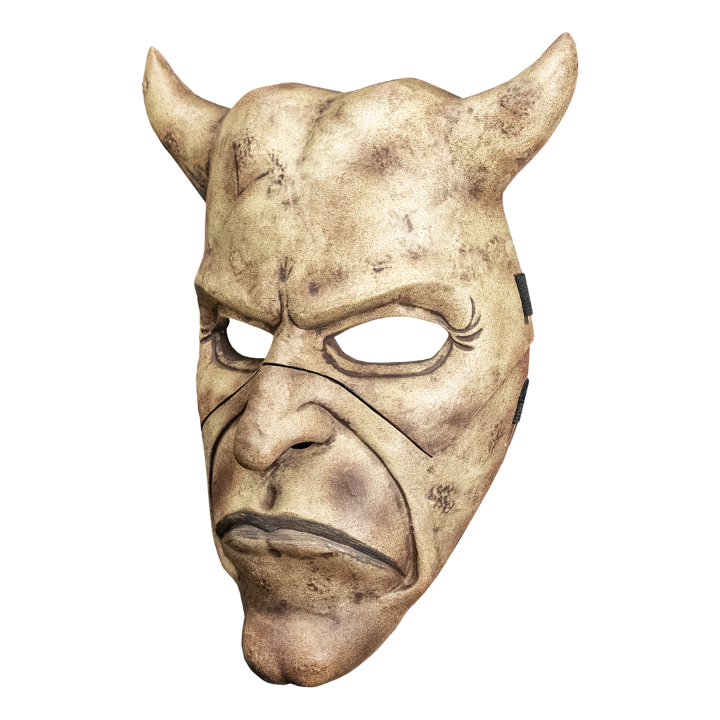 Grabber mask left side view. Face mask, dirty off-white and brown. Horns on both sides of head. Frowning mouth. Cleft chin.