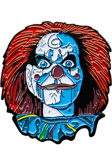 Enamel Pin. Mary Shaw Clown, head and neck, wearing ruffled blue clown collar. Distressed finish, white skin, ventriloquist dummy clown face, spiral curl drawn on forehead, rosy red spots on cheeks, red nose, bright red hair, black-rimmed, blue eyes. Bright red lips, hinged lower jaw.
