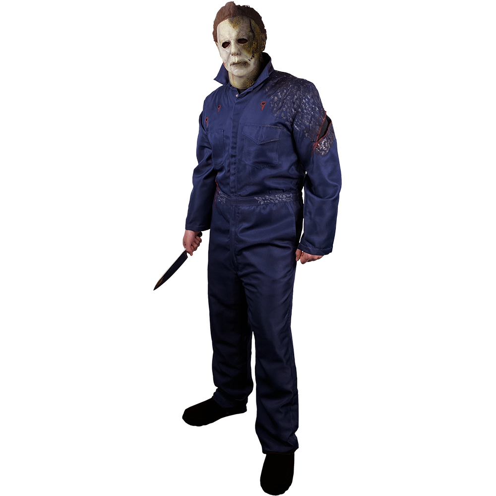 Person wearing Michael Myers mask and blue coveralls distressed with bloody cut in left upper arm. Holding knife in right hand. Black shoes.