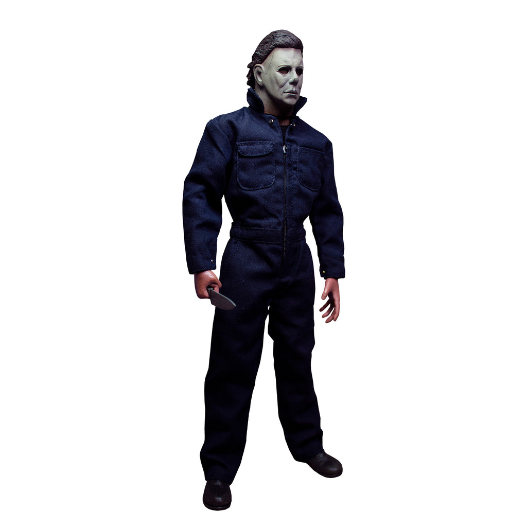 Michael Myers 12" figure.  Right side view. White mask, brown hair, wearing blue coveralls, black boots, holding butcher knife in right hand.