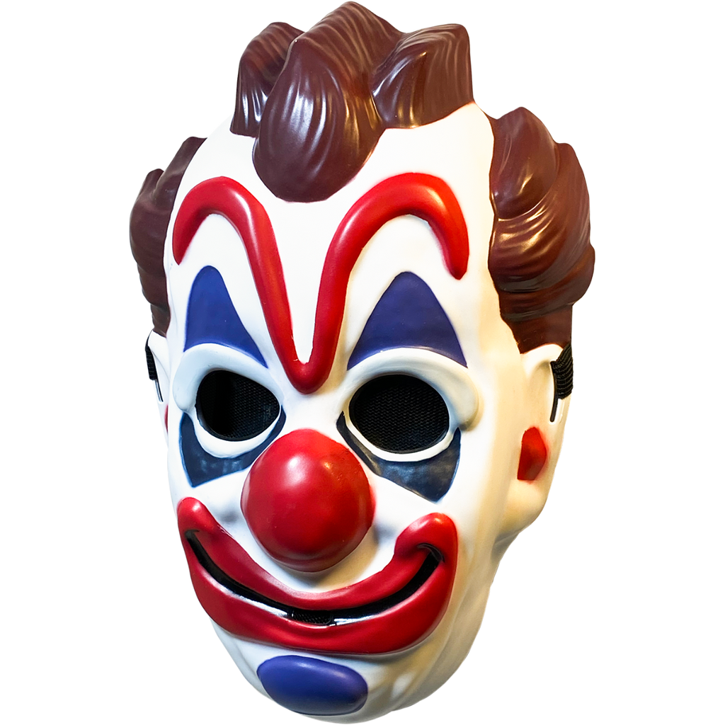 Plastic mask, left view. White clown face, brown hair on top and sides of head. Exaggerated red eyebrows, nose, and smiling mouth. Blue above and below eyes and on chin