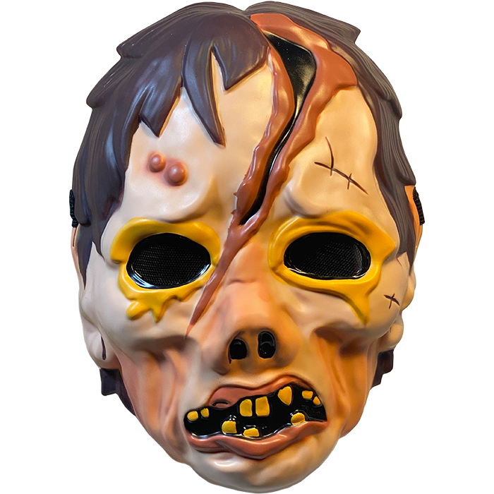 Plastic mask, front view. Zombie face. Brown hair. Yellow rimmed black eyes. Large gash on forehead to bridge of pug nose.  Misshapen mouth with pink lips and sparse yellow teeth.