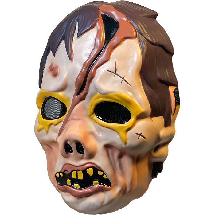 Plastic mask, left side view. Zombie face. Brown hair. Yellow rimmed black eyes. Large gash on forehead to bridge of pug nose. Misshapen mouth with pink lips and sparse yellow teeth.