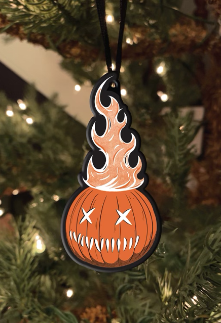 Ornament.  Orange jack o' lantern with flames coming out the top, two x eyes, several straight hash marks for mouth