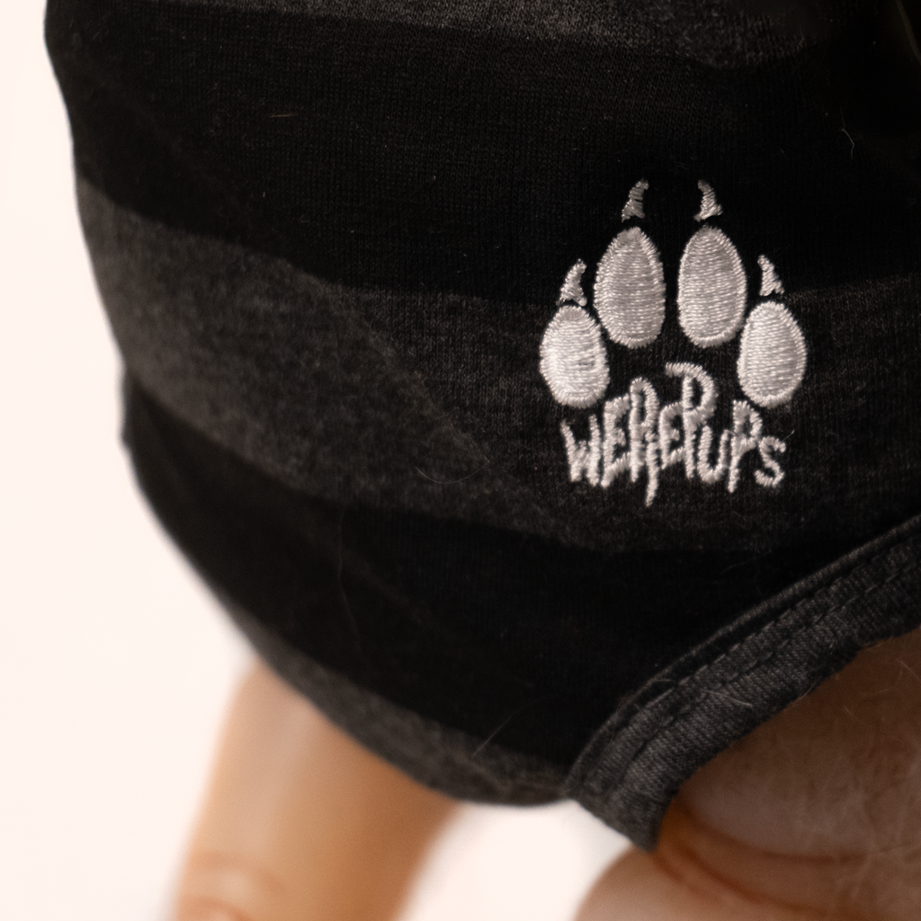 Close up of bottom of gray and black striped onesie, white logo, canine toe print with claws, white text reads werepups.