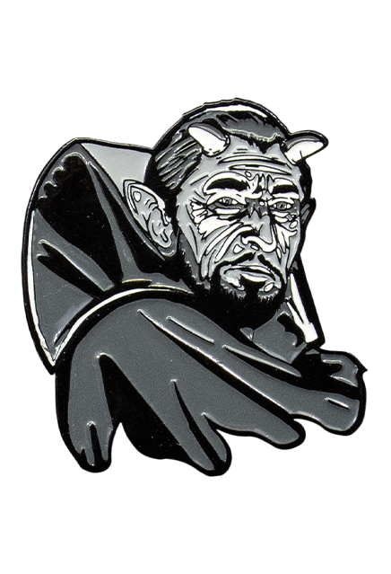 Enamel pin. Black and white illustration. Man head and shoulders. Dark hair, 2 horns on head, large pointy ears, beard and moustache, wearing high-collared cape.